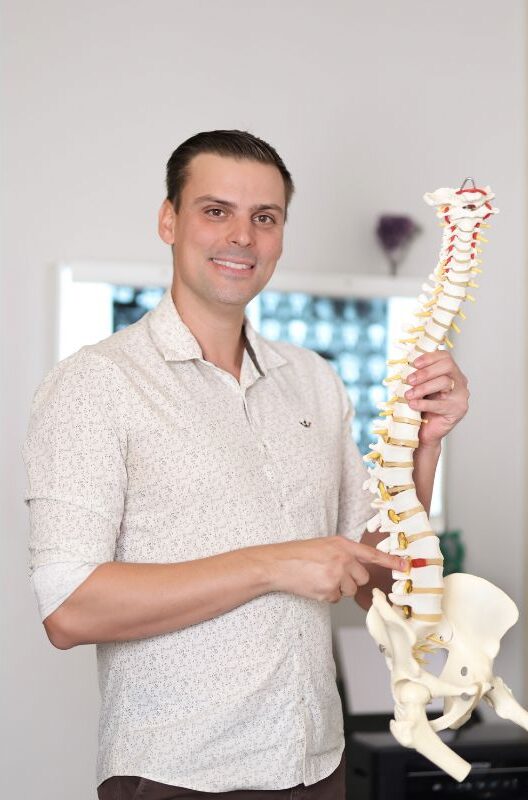 Quiropraxista explicando um modelo de coluna vertebral Quiropraxista explicando um modelo de coluna vertebral